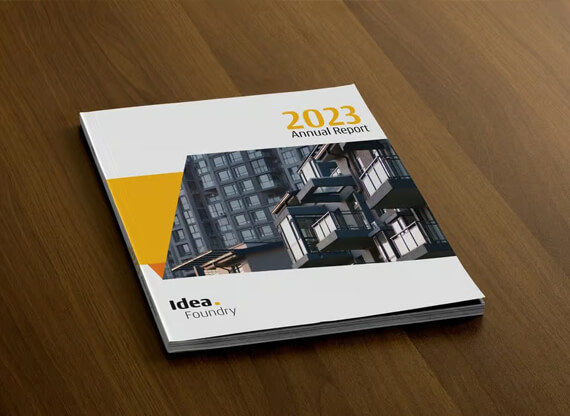 Ein hochwertiger Jahresbericht liegt auf dunklem Eichenholz. Das Cover zeigt eine Reihe moderner Bürogebäude und die Headline „2023 Annual Report“.