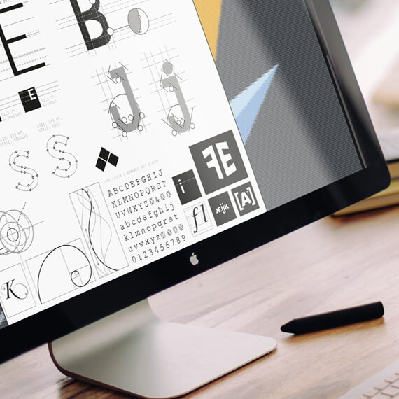 Bildschirm mit dem Programm Adobe Illustrator, durch das typografische Feinheiten überarbeitet werden. Man sieht Ankerpunkte und Linien verschiedener Symbole und Buchstaben.