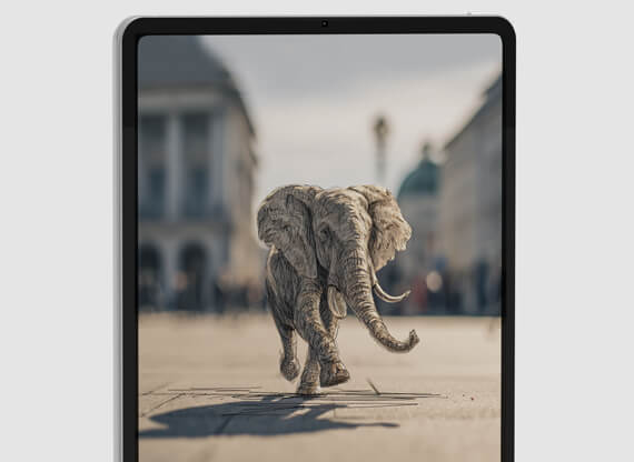 Ein iPad, welches eine Bildkonzeption in Form einer Augmented Reality Elefantenzeichnung am Karlsplatz / Stachus in München anzeigt.