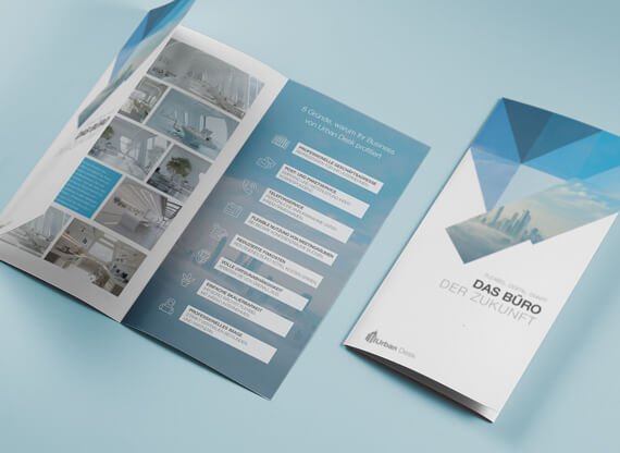 Die Flyergestaltung wird anhand eines aufgeschlagenen Flyers präsentiert, der auf einem blauen Schreibtisch liegt und durch ansprechendes Layout sowie klare Typografie sofort ins Auge fällt.