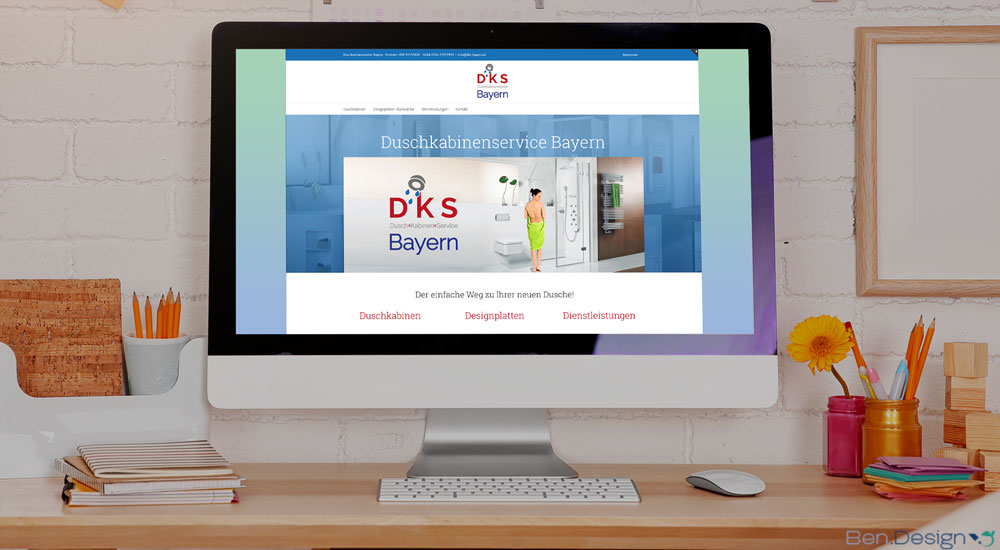 Ein iMac 24" auf einem Bürotisch. Auf dem Bildschirm wird die Website von "dks Bayern" angezeigt.